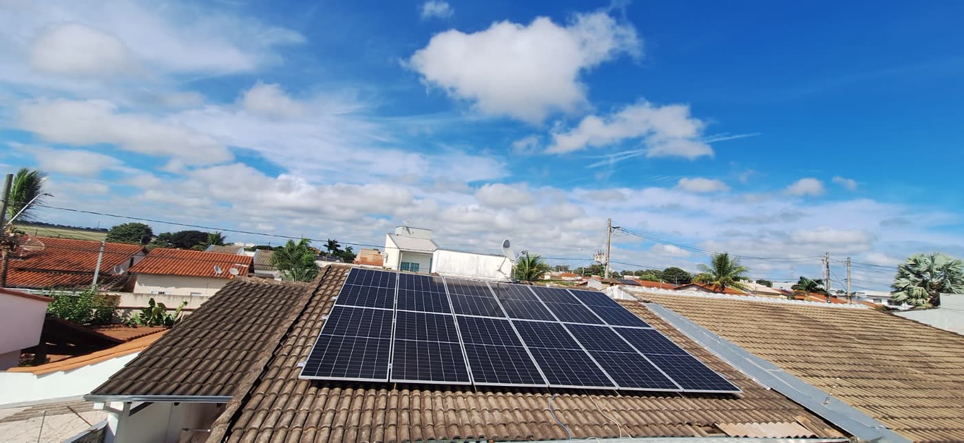 Painéis solares instalados em telhado de residência sob céu azul